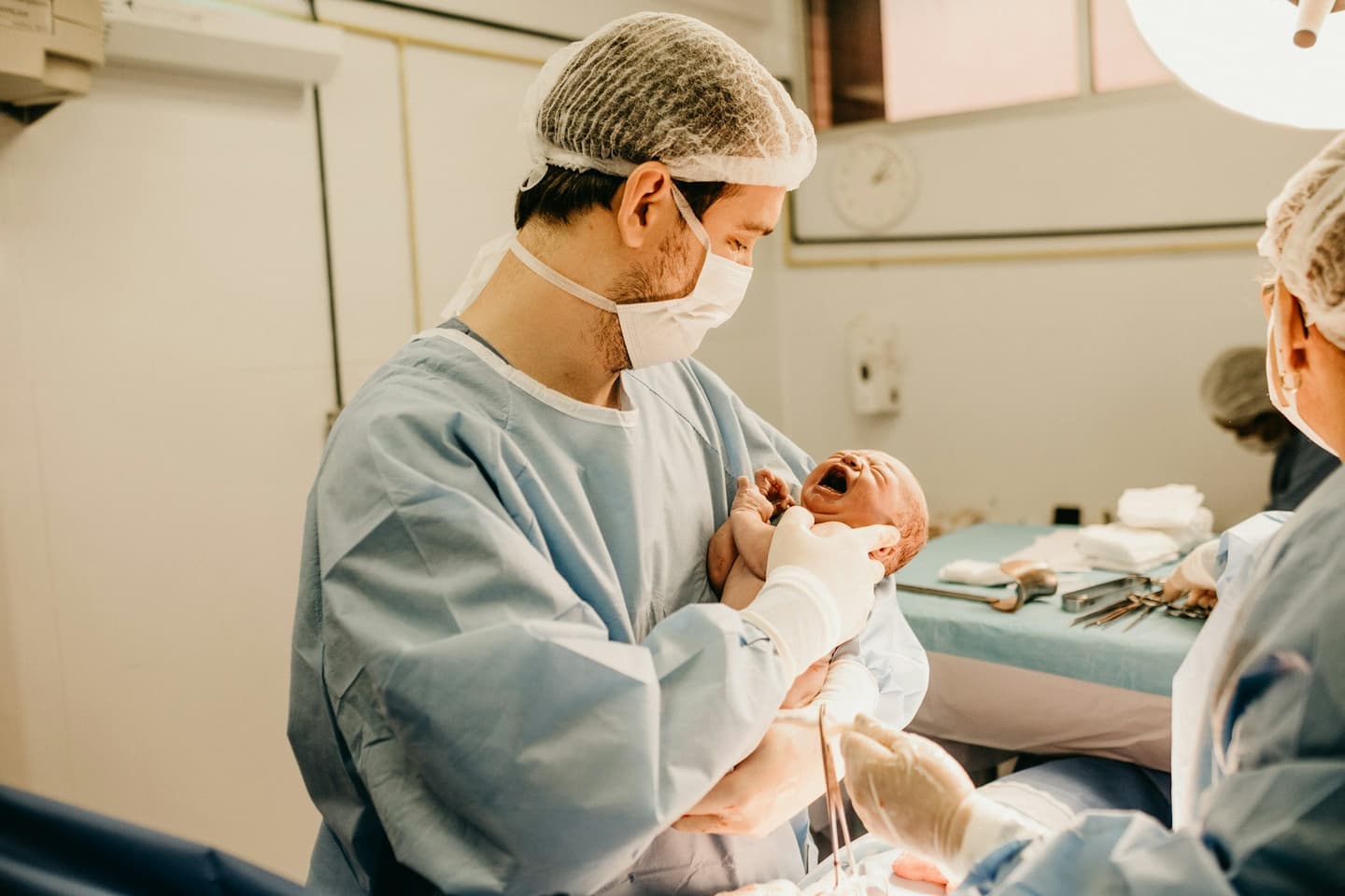 Newborn being held by a man