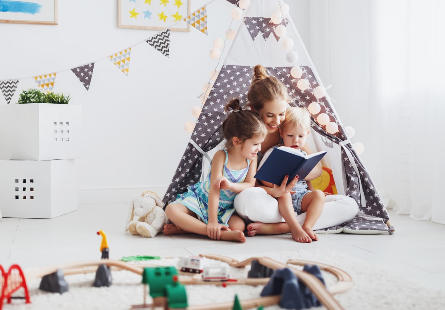 young children with guardian reading in inside tent