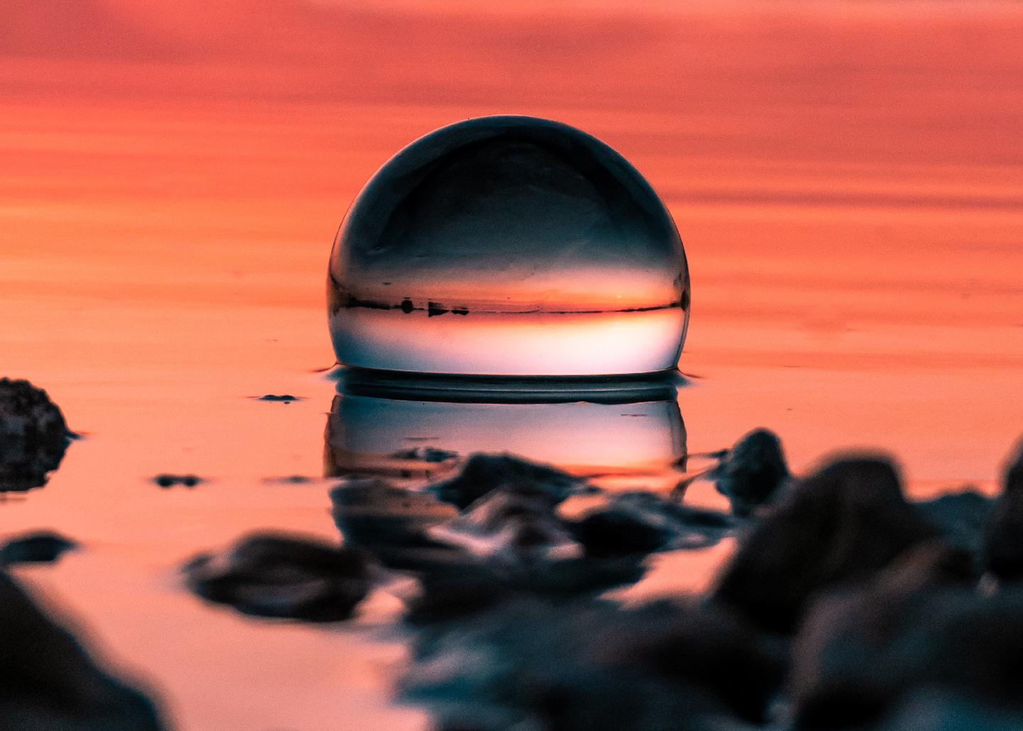 Glass sphere in water at sunset