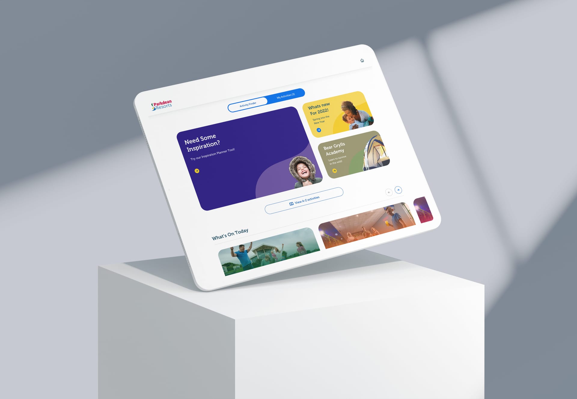 Tablet displaying Parkdean Resorts website with colourful activity panels and inspiration planner on a white pedestal.