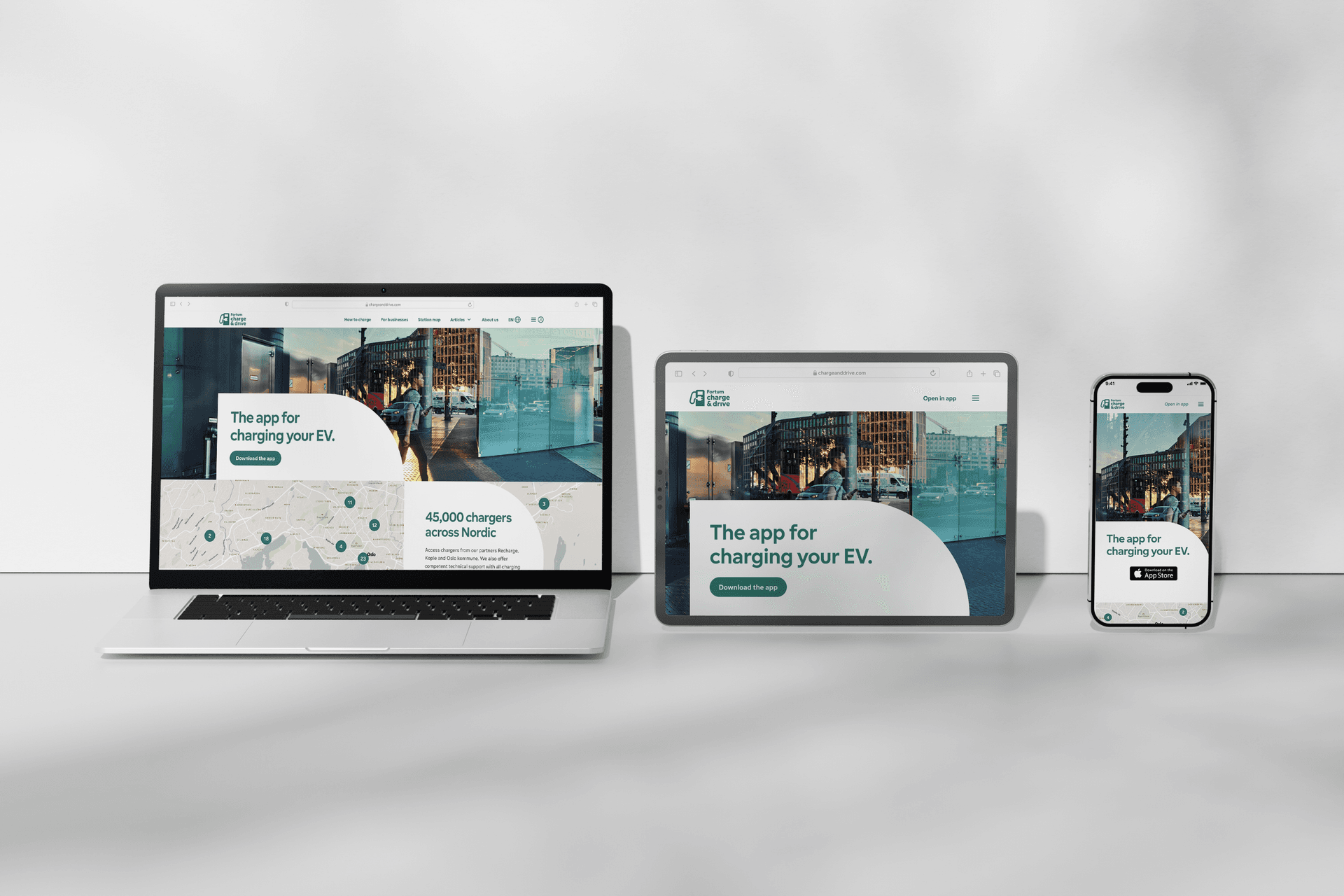 Charge & Drive EV charging app displayed on laptop, tablet and smartphone devices against a grey background.