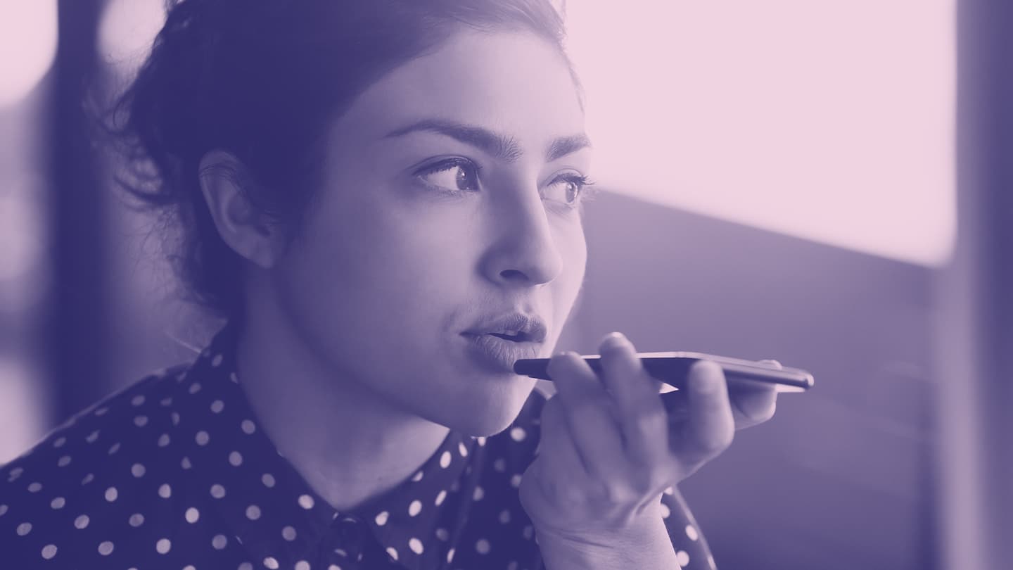 Colorized photo of a person holding and speaking into a smartphone