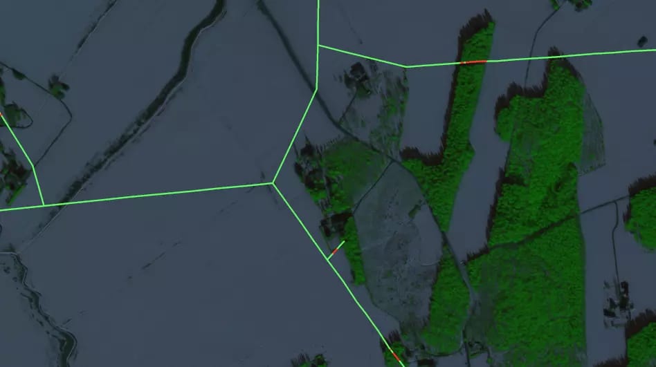 Aerial view of agricultural land with green vegetation patches outlined by bright green boundary lines on a grey background.