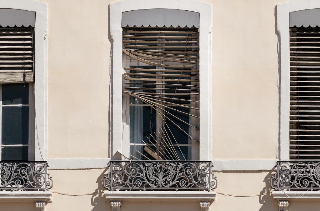 Photo showing several windows with one window that has broken blinds